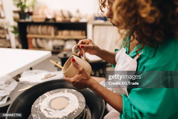 close-up of a woman making a craft product of ceramic - black sculptor stock pictures, royalty-free photos & images