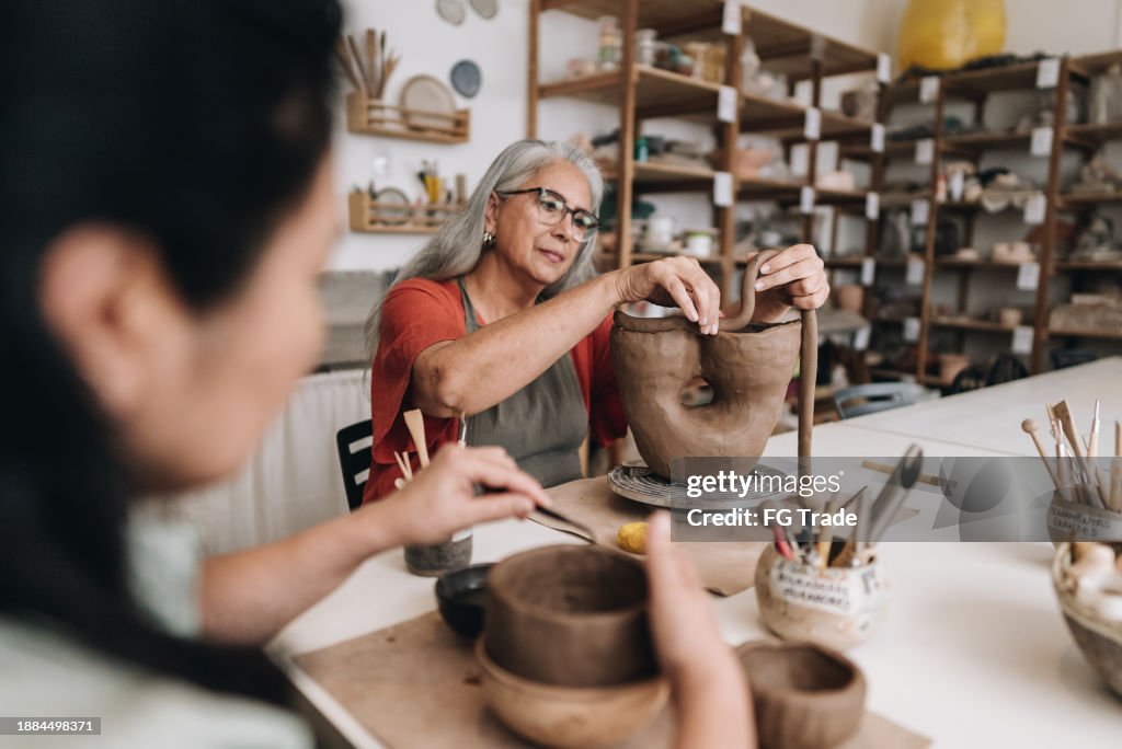 Senior woman making a craft product on a ceramics workshop