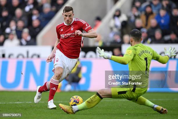 Chris Wood of Nottingham Forest runs ahead of Martin Dubravka of Newcastle United to score their sides third goal during the Premier League match...