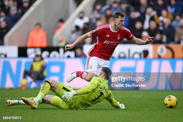 Chris Wood of Nottingham Forest runs ahead of Martin Dubravka of Newcastle United to score their sides third goal during the Premier League match...