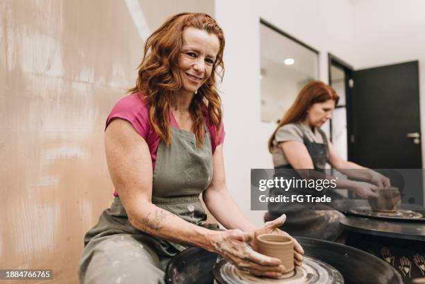 portrait of a mature woman on pottery class at a ceramics workshop - earthenware stock pictures, royalty-free photos & images