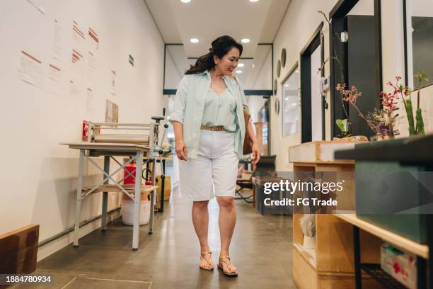 mature woman walking on art studio - museum curator stock pictures, royalty-free photos & images