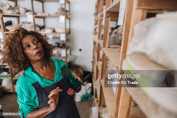 senior woman working on a ceramics industry - black sculptor stock pictures, royalty-free photos & images