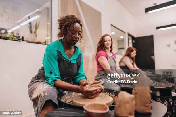 senior woman on pottery class at a ceramics workshop - black sculptor stock pictures, royalty-free photos & images