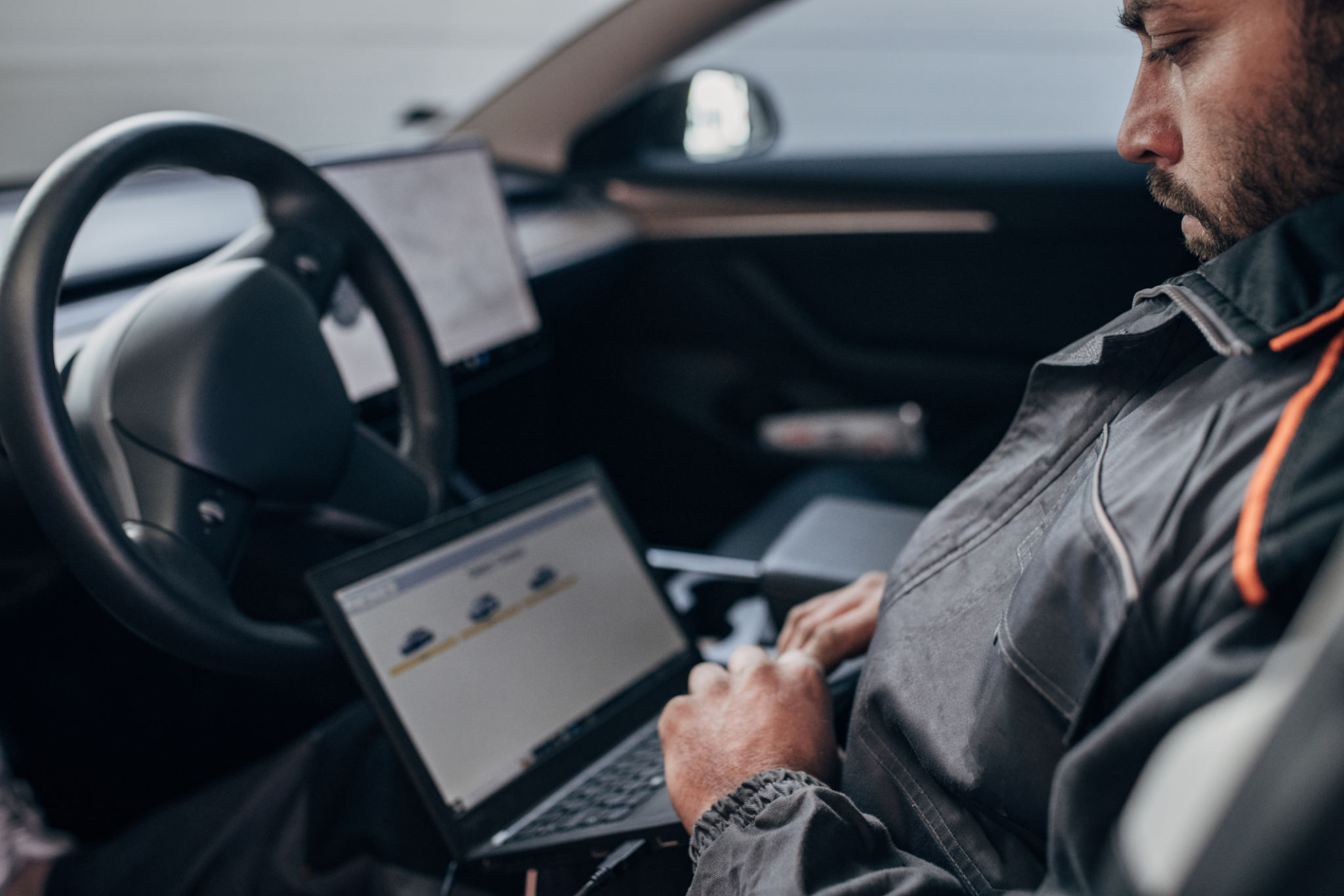 Mécanicien faisant le diagnostic de voiture dans l’atelier de réparation d’automobile Mécanicien faisant le diagnostic de voiture dans l’atelier de réparation d’automobile