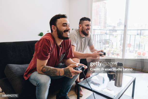 friends playing video games at apartment - roommate stock pictures, royalty-free photos & images