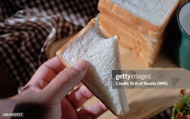 hand holding homemade sandwich with missing bite - sandwich triangle stock pictures, royalty-free photos & images