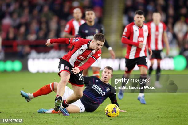 James McAtee of Sheffield United runs with the ball as Ross Barkley of Luton Town looks on during the Premier League match between Sheffield United...