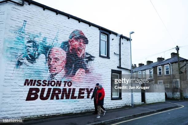 Fans of Burnley walk past a mural of Vincent Kompany, Manager of Burnley, prior to the Premier League match between Burnley FC and Liverpool FC at...