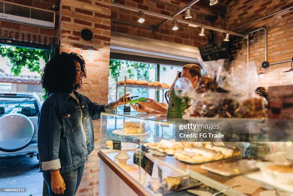 Customer paying with mobile phone at bakery