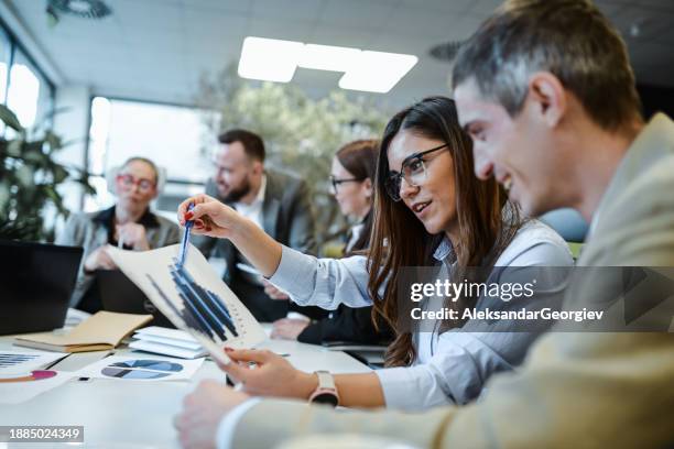 female financial manager explaining profit spikes to male project manager during meeting - vice president office stock pictures, royalty-free photos & images