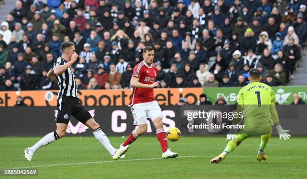 Chris Wood of Nottingham Forest beats Newcastle goalkeeper Martin Dubravka to score his sides second goal as Sven Botman looks on during the Premier...
