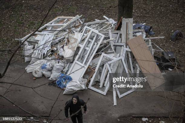 People carry the furnitures out of the destroyed building after Russian airstrikes which killed 6 and injured around 28 people including a baby and...