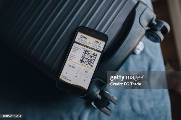 close-up of a mobile phone with airplane ticket data on top of suitcase - airplane ticket stock pictures, royalty-free photos & images