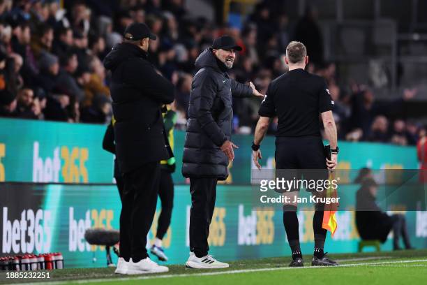 Juergen Klopp, Manager of Liverpool, interacts with Assistant Referee Scott Ledger during the Premier League match between Burnley FC and Liverpool...