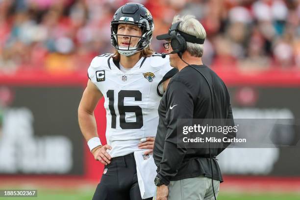 Trevor Lawrence of the Jacksonville Jaguars talks with head coach Doug Pederson during the first half of the game against the Tampa Bay Buccaneers at...