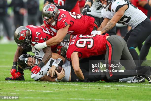 Trevor Lawrence of the Jacksonville Jaguars is sacked by Lavonte David, Logan Hall and Anthony Nelson of the Tampa Bay Buccaneers during the first...