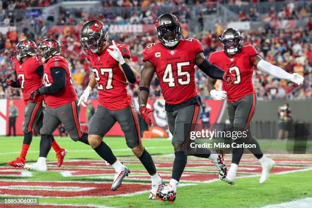 Zyon McCollum, Devin White and Yaya Diaby of the Tampa Bay Buccaneers celebrate a turnover during the second half of the game against the...