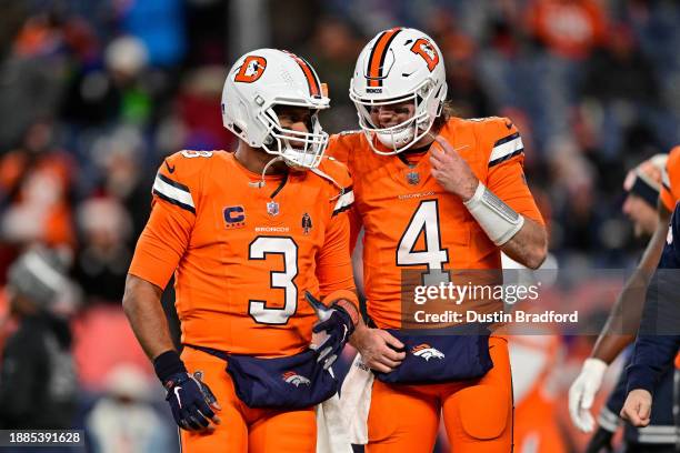 Russell Wilson and Jarrett Stidham of the Denver Broncos warm up before a game against the New England Patriots at Empower Field at Mile High on...