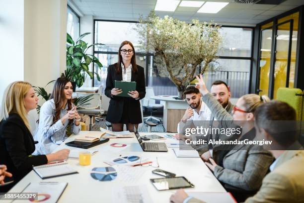 senior female financial manager, die während des meetings nützlichen input gibt - projektmanagement stock-fotos und bilder
