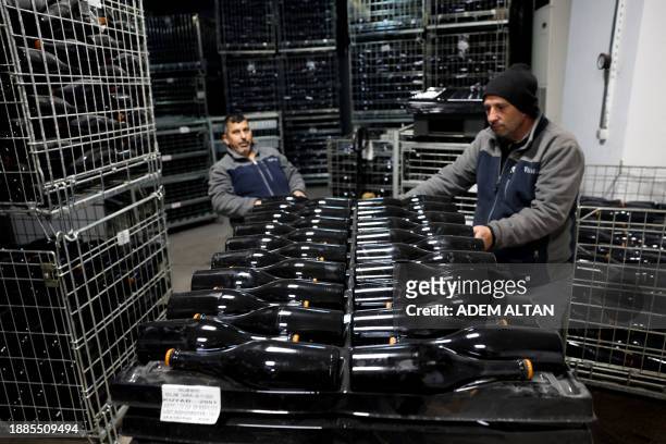 Employees move bottles of sparkling wine at the Vinkara winery in Kalecik in the district of Ankara Province , on December 18, 2023. Turkish...