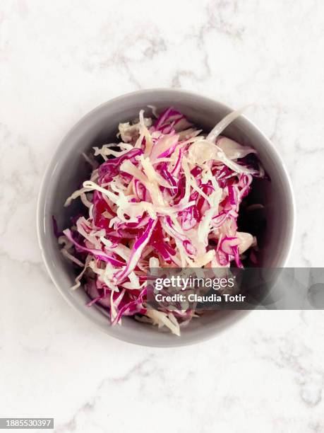 bowl of red cabbage salad on white marble background - coleslaw stock pictures, royalty-free photos & images