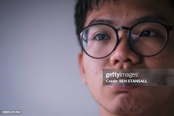 Hong Kong democracy activist Tony Chung poses in a bedroom in Britain on December 29, 2023 after fleeing Hong Kong. The Hong Kong activist said on...