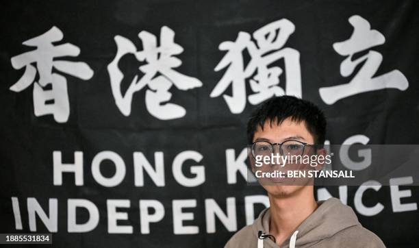 Hong Kong democracy activist Tony Chung poses in front of a flag reading "Hong Kong Independence" hanged on a wall in a bedroom in Britain on...