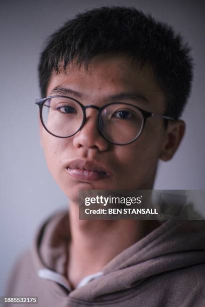 Hong Kong democracy activist Tony Chung poses in a bedroom in Britain on December 29, 2023 after fleeing Hong Kong. The Hong Kong activist said on...