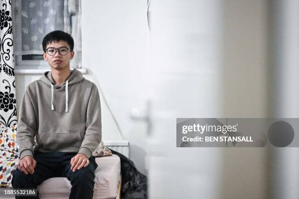 Hong Kong democracy activist Tony Chung poses in a bedroom in Britain on December 29, 2023 after fleeing Hong Kong. The Hong Kong activist said on...