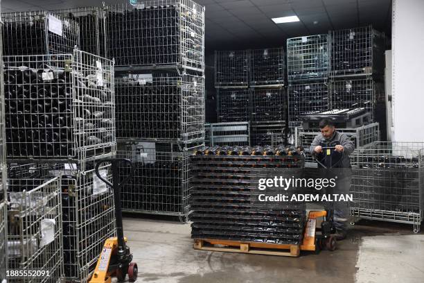 An employee moves bottles of sparkling wine at the Vinkara winery in Kalecik in the district of Ankara Province, on December 18, 2023. Turkish...