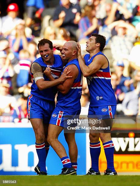 Brad Johnson, Nathan Eagleton and Paul Dimattina of the Bulldogs celebrate a goal during the Round one AFL match between the Western Bulldogs and the...