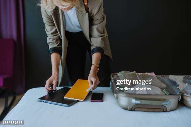 anonymous woman packing things in the suitcase - passport open stock pictures, royalty-free photos & images