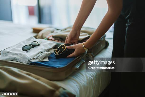 anonymous woman packing a suitcase on the bed - inpakken stockfoto's en -beelden