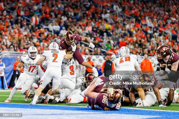 Darius Taylor of the Minnesota Golden Gophers leaps over a scrum of players in the third quarter of the Quick Lane Bowl game against the Bowling...