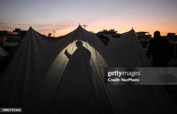 Palestinian boy is sitting inside a tent at a camp for displaced people in Deir al-Balah, in the central Gaza Strip, on December 29 amid ongoing...