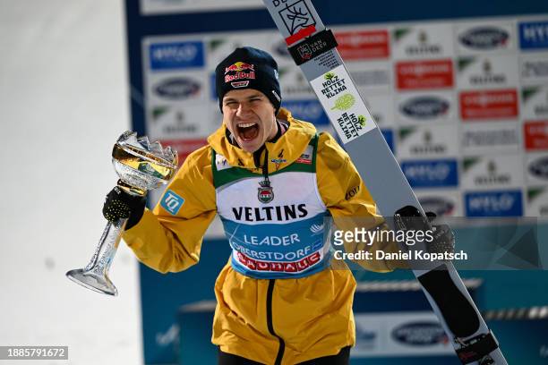 Andreas Wellinger of Germany celebrates next to the podium after the second round of the FIS World Cup Ski Jumping Four Hills Tournament Men...