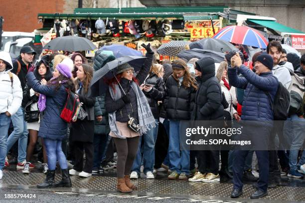 Tourists shelter from wind and rain under umbrellas on Westminster Bridge in London as Storm Gerrit continues to cause damage to properties and...