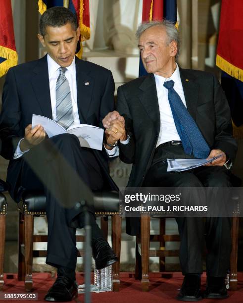 President Barack Obama reads his program while grasping the hand of Elie Wiesel, Founding Chairman, US Holocaust Memorial Council after Wiesel's...