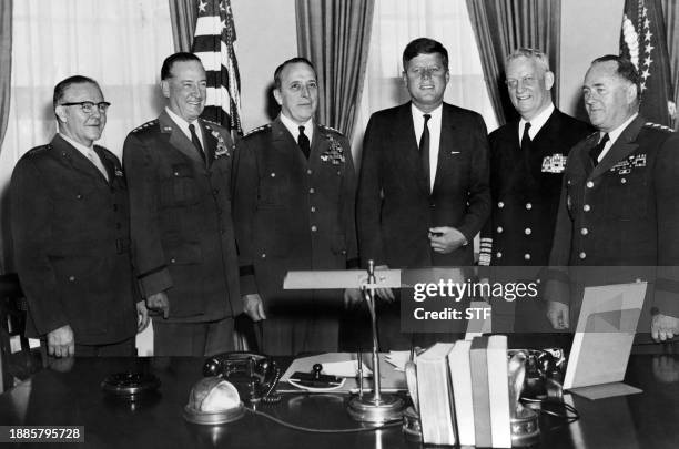 President John Fitzgerald Kennedy poses with his Joint Chiefs of Staff in the Oval Office of the White House in Washington, DC, in February 1961....