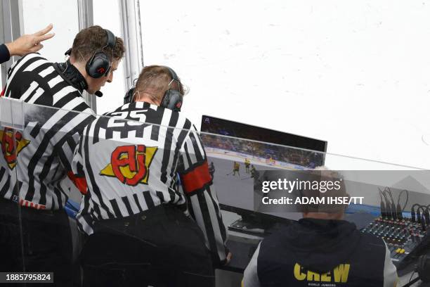 Referees look at video footage during the Group A ice hockey match between Canada and Sweden of the IIHF World Junior Championship in Gothenburg,...