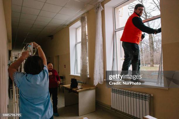 Volunteers are cleaning the windows that an explosion broke in a local hospital, in Kharkiv, Ukraine, on december 29, 2023.