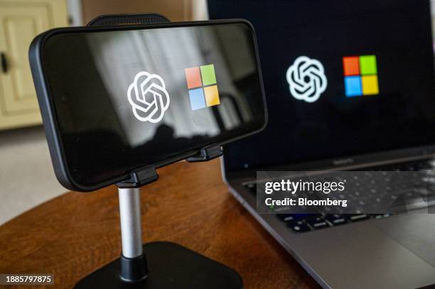 The OpenAI and Microsoft logos on a smartphone and laptop arranged in Crockett, California, US, on Friday, Dec. 29, 2023. Microsoft has invested some...