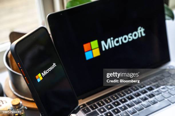The Microsoft logo on a smartphone and laptop arranged in Crockett, California, US, on Friday, Dec. 29, 2023. Microsoft has invested some $13 billion...