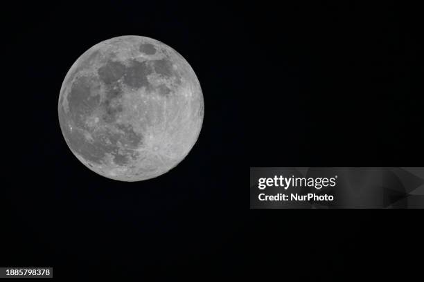 Full Moon rises over the city of Eindhoven in the dark winter night sky. The last full moon of the year is the Cold Moon, the 13th full moon of the...