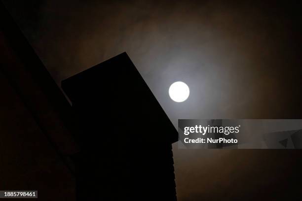 Full Moon rises over the city of Eindhoven in the dark winter night sky. The last full moon of the year is the Cold Moon, the 13th full moon of the...