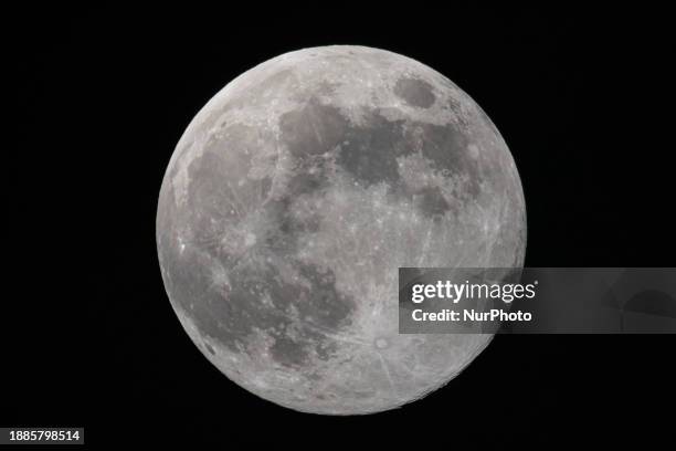 Full Moon rises over the city of Eindhoven in the dark winter night sky. The last full moon of the year is the Cold Moon, the 13th full moon of the...