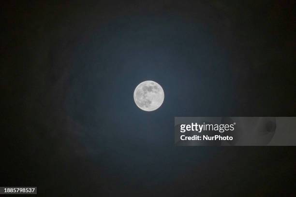 Full Moon rises over the city of Eindhoven in the dark winter night sky. The last full moon of the year is the Cold Moon, the 13th full moon of the...