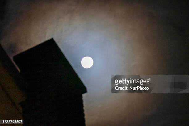 Full Moon rises over the city of Eindhoven in the dark winter night sky. The last full moon of the year is the Cold Moon, the 13th full moon of the...