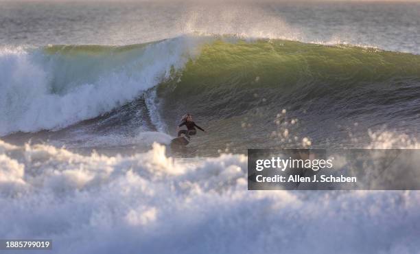 Newport Beach, CA A young surfer does a bottom turn while surfing a big wave at sunset in Newport Beach Thursday, Dec. 28, 2023.